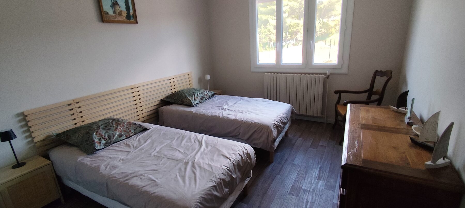 Chambre avec deux lits jumeaux, sol en bois